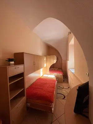 a small room with a bed and a table in a room at Apartma na Starem Placu in Idrija