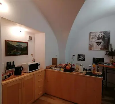 a kitchen with a microwave on top of wooden cabinets at Apartma na Starem Placu in Idrija
