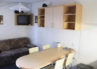 a living room with a wooden table and a couch at Apartments Rogla in Zreče