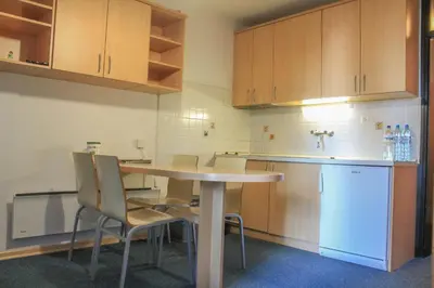 a kitchen with a table and chairs and a refrigerator at Apartments Rogla in Zreče