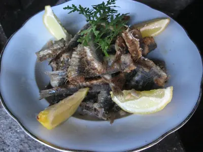 a plate of food with meat and lemon slices at Hiša Koražija in Rogaška Slatina