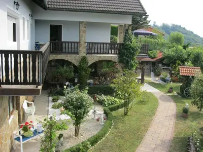 a garden in front of a house with a balcony at Hiša Koražija in Rogaška Slatina