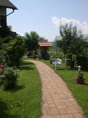a brick path in a park with a bench at Hiša Koražija in Rogaška Slatina