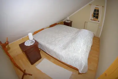 a small bedroom with a bed and a wooden floor at Tourist farm Samec in Sele