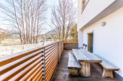 a wooden bench on the balcony of a house at Apartments Plan Kranjska Gora in Kranjska Gora