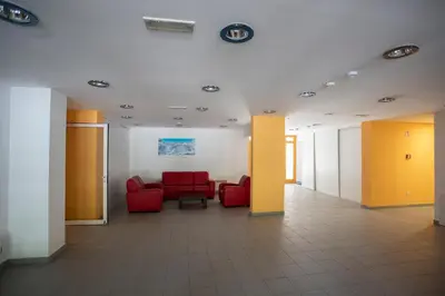 a waiting room with red chairs and yellow walls at Apartments Plan Kranjska Gora in Kranjska Gora