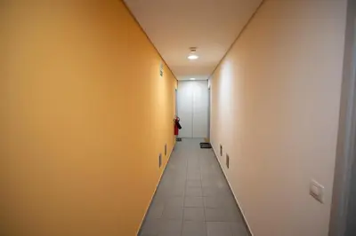 a hallway with yellow walls and a long corridor at Apartments Plan Kranjska Gora in Kranjska Gora