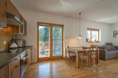 a kitchen and dining room with a table and chairs at Apartments Plan Kranjska Gora in Kranjska Gora