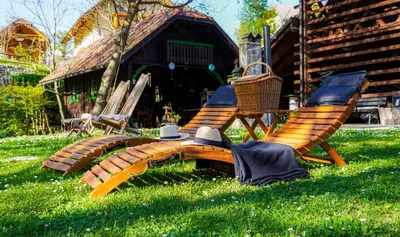 a pair of chairs and a hat sitting in the grass at Resort pod orehi - Bled - Apartma & Glamping & Savna in Bled
