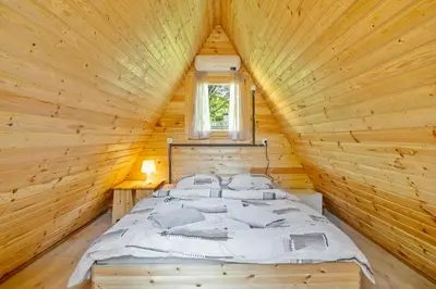 a bedroom with a bed in a wooden cabin at Resort pod orehi - Bled - Apartma & Glamping & Savna in Bled