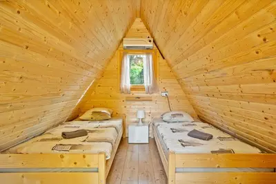 a bedroom with two beds in a wooden cabin at Resort pod orehi - Bled - Apartma & Glamping & Savna in Bled