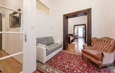 a living room with a couch and a chair at Codelli Deluxe Fresco City Centre APP With Balcony in Ljubljana