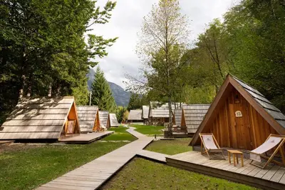 a group of lodges with chairs and a wooden deck at Camp Korita in Soča