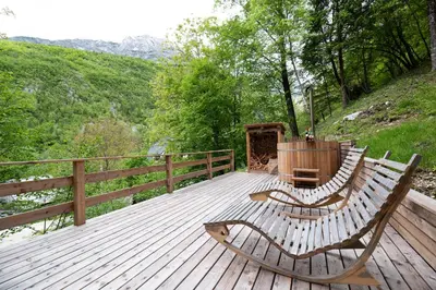 a wooden deck with two benches sitting on it at Camp Korita in Soča