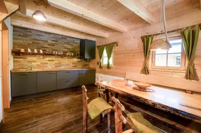 a kitchen with a wooden floor and a wooden table at Camp Korita in Soča