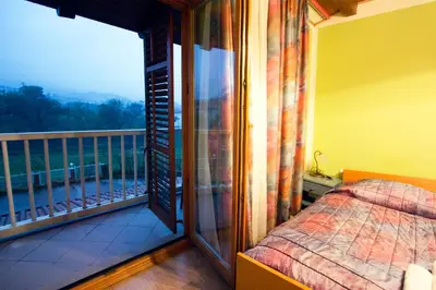 a bedroom with a balcony with a bed and a window at Tourist Farm Gregorič in Zalošče
