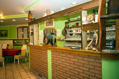 a bar in a restaurant with green walls at Tourist Farm Gregorič in Zalošče