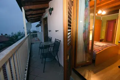 a balcony with a bed and a table and chairs at Tourist Farm Gregorič in Zalošče