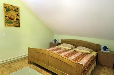 a bedroom with a wooden bed with two night stands at Tourist Farm Ferencovi in Cankova
