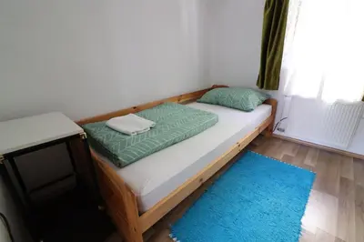 a bed in a room with a blue rug at Guesthouse Veles in Slovenska Bistrica