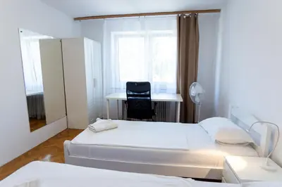 a room with two beds and a desk and a chair at Emona Guesthouse Ljubljana in Ljubljana