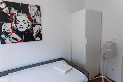 a bedroom with a bed with a painting on the wall at Emona Guesthouse Ljubljana in Ljubljana