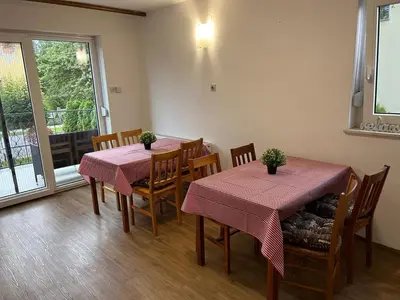 a dining room with two tables and chairs with plants on them at Emona Guesthouse Ljubljana in Ljubljana