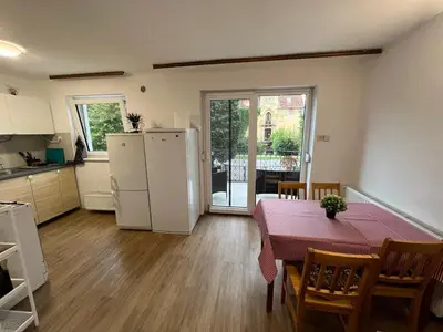 a kitchen and dining room with a table and a refrigerator at Emona Guesthouse Ljubljana in Ljubljana