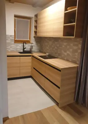 a kitchen with wooden cabinets and a sink at Apartment Appohorje in Pohorje