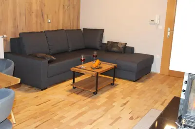 a living room with a couch and a table with wine glasses at Apartment Appohorje in Pohorje