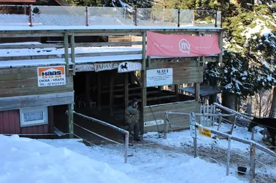a man standing outside of a building in the snow at Apartment Appohorje in Pohorje