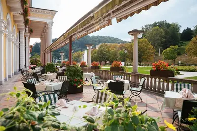 an outdoor patio with tables and chairs and flowers at Grand Hotel Rogaška Premium in Rogaška Slatina