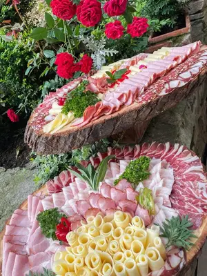 two large trays of food on a table with flowers at Guesthouse Jurcek in Zreče