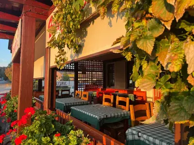 a restaurant with green tables and chairs and flowers at Guesthouse Jurcek in Zreče
