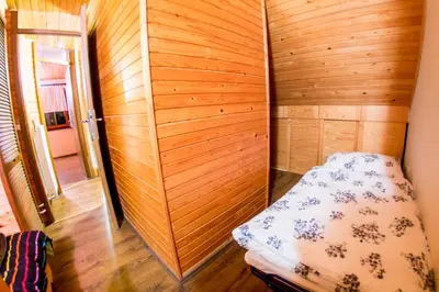 a small room with a bed in a wooden wall at Rogla Chalet Urska in Resnik