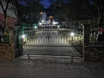 a wrought iron gate with lights at night at Apartments Ina in Rogaška Slatina