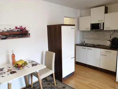 a kitchen with a table and a white refrigerator at Apartments Ina in Rogaška Slatina