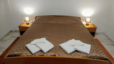a bed with two white towels on it with two night stands at Apartments Ina in Rogaška Slatina