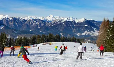 a group of people skiing down a snow covered slope at Apartments Peternelj in Cerkno