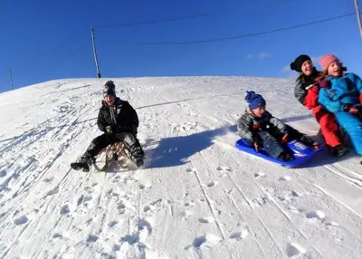 a group of people on snowboards on a snow covered slope at Apartments Peternelj in Cerkno