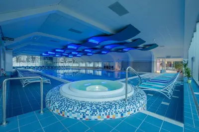 a swimming pool with a hot tub in a building at Apartments Peternelj in Cerkno