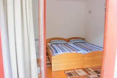 a small bed in a small room with a mirror at Farm Stay Loger in Ljubno