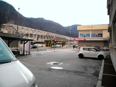 a parking lot with a white car parked in front of a building at Studio Jesenice in Jesenice