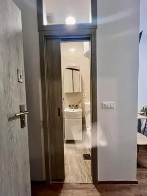 a door to a bathroom with a sink and a toilet at Studio apartment Sisters3 in Ljubljana