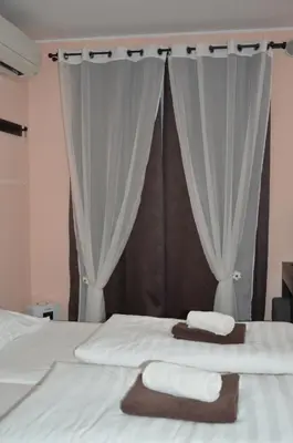 a bedroom with two towels on a bed with curtains at Apartment Kancler in Nova Gorica