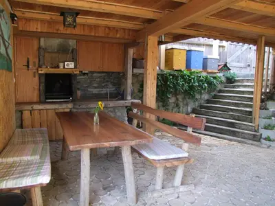 a wooden picnic table and benches in a pavilion at Garden ECO houses Čebelica in Bohinj