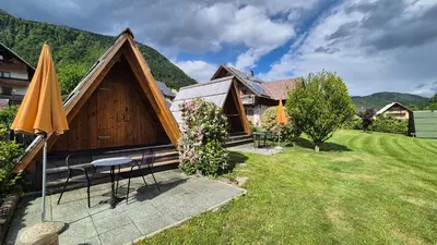 a house with a table and an umbrella in the yard at Garden ECO houses Čebelica in Bohinj