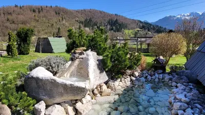 a garden with a stone sink in a yard at Garden ECO houses Čebelica in Bohinj