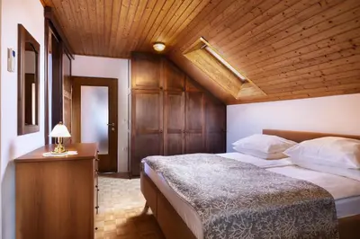 a bedroom with a large bed and a wooden ceiling at Lake Bled Apartment Zerovec in Bled