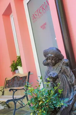 a statue of a girl in a hat next to a bench at Boutique Hotel Asteria in Ljubljana